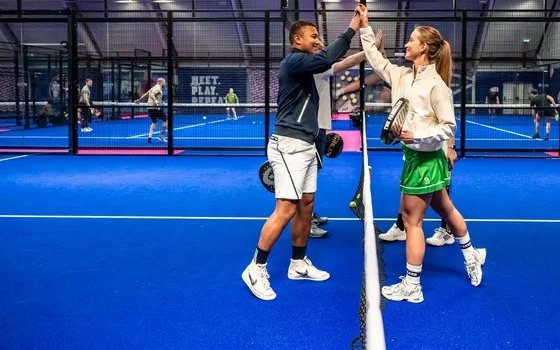 Twee spelers geven elkaar een high five over het net